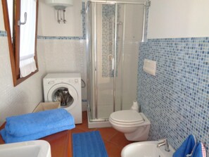 Een douche, een haardroger, een bidet, handdoeken