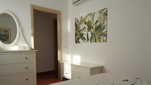 Un dormitorio con cama, cómoda y un cuadro en la pared.
