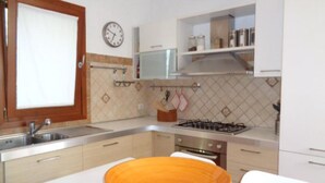 Una cocina con lavamanos, estufa y armarios.