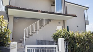 A two-story building with a staircase leading to the upper floor, a door, and a small balcony. - N196 - Numana, delightful two-room apartment with garden and sea view (Numana)