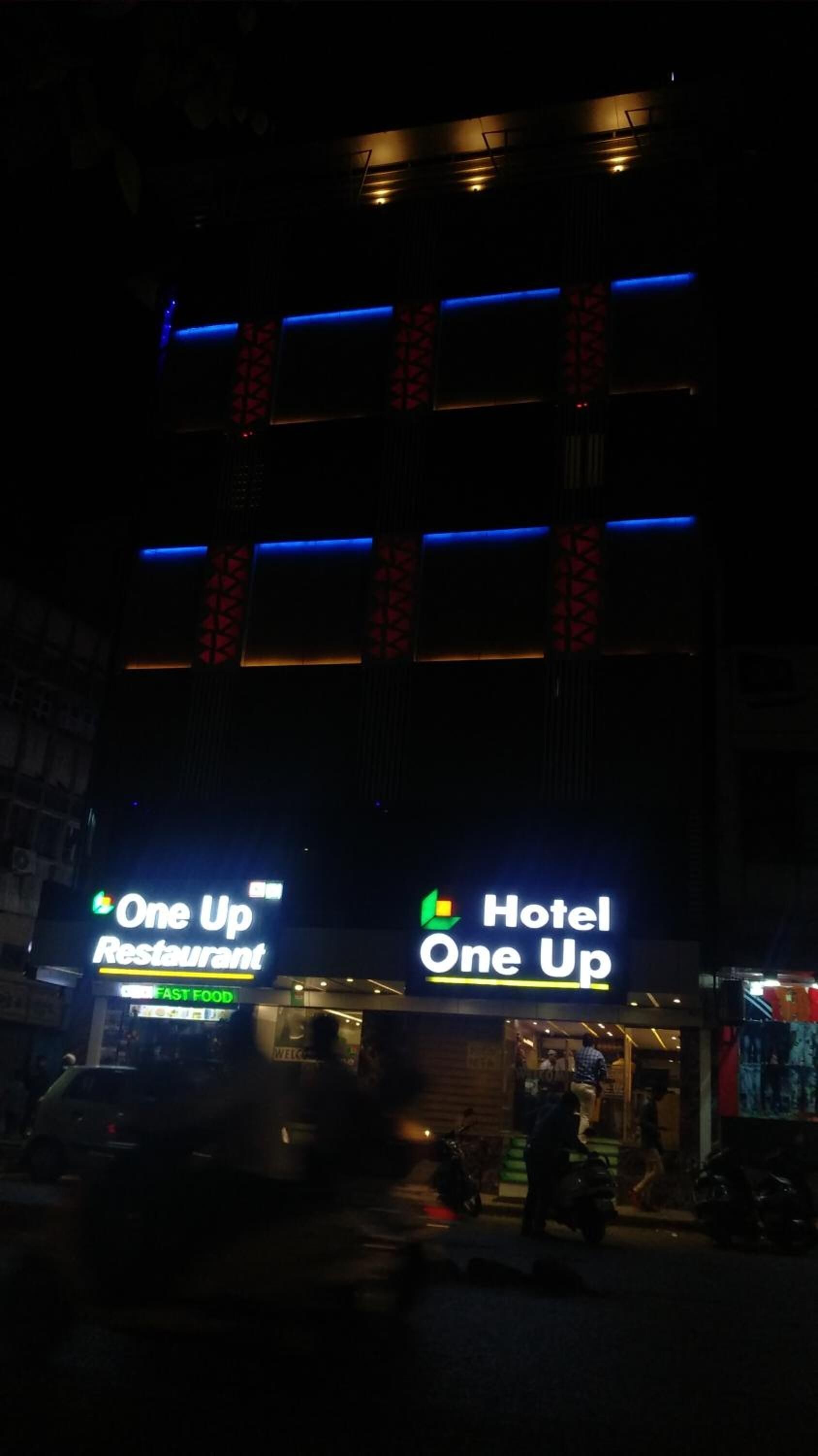 A building with a sign for 'One Up Restaurant' and 'Hotel One Up'.