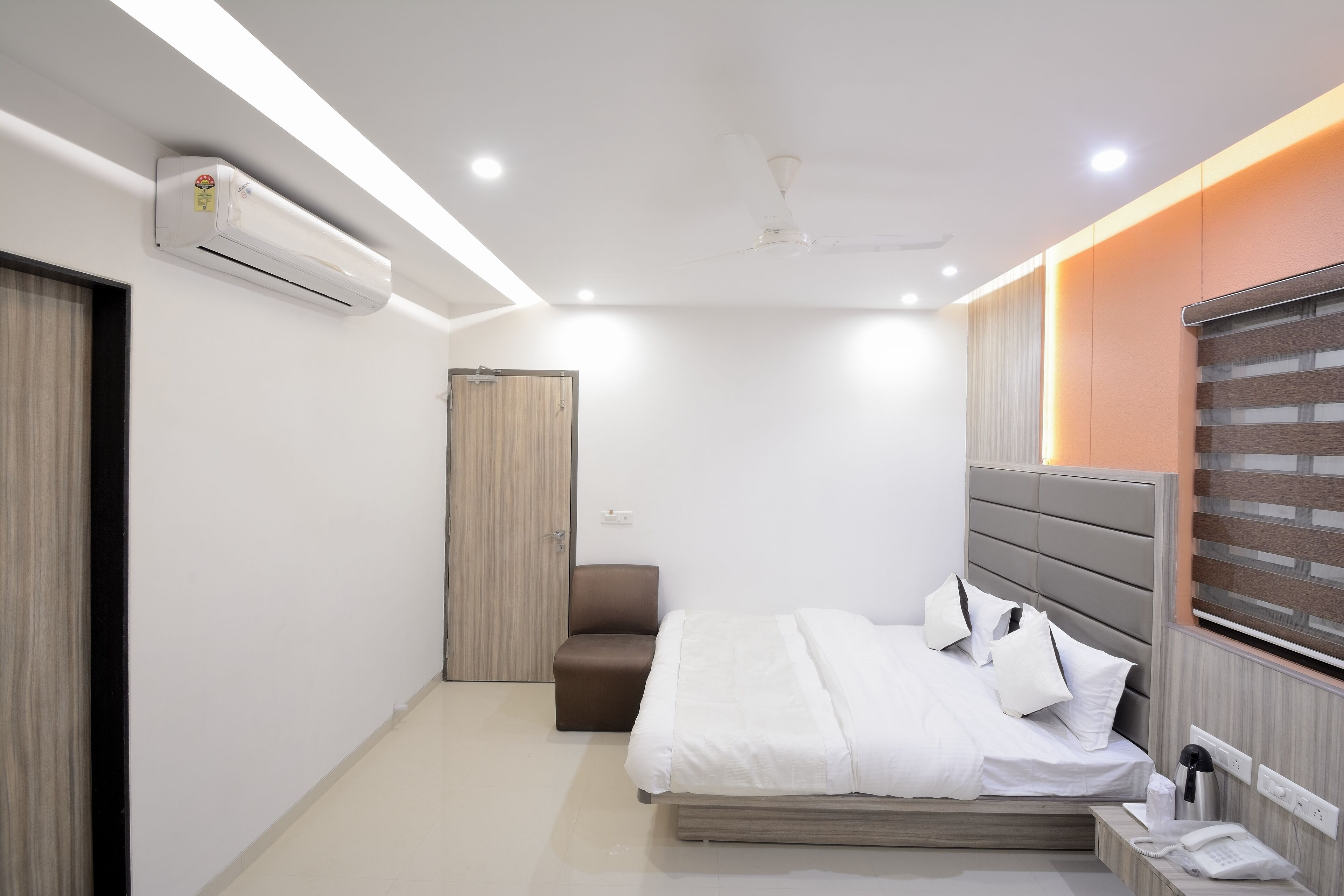 Une chambre d’hôtel moderne équipée d’un lit, d’une table de chevet et d’un appareil de climatisation.