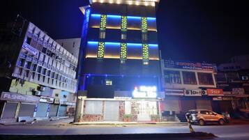 A multi-story building with illuminated vertical stripes and a sign for 'Fashion Point' on the ground floor.