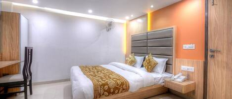 A modern hotel room with a large bed, bedside table, and a built-in wardrobe.