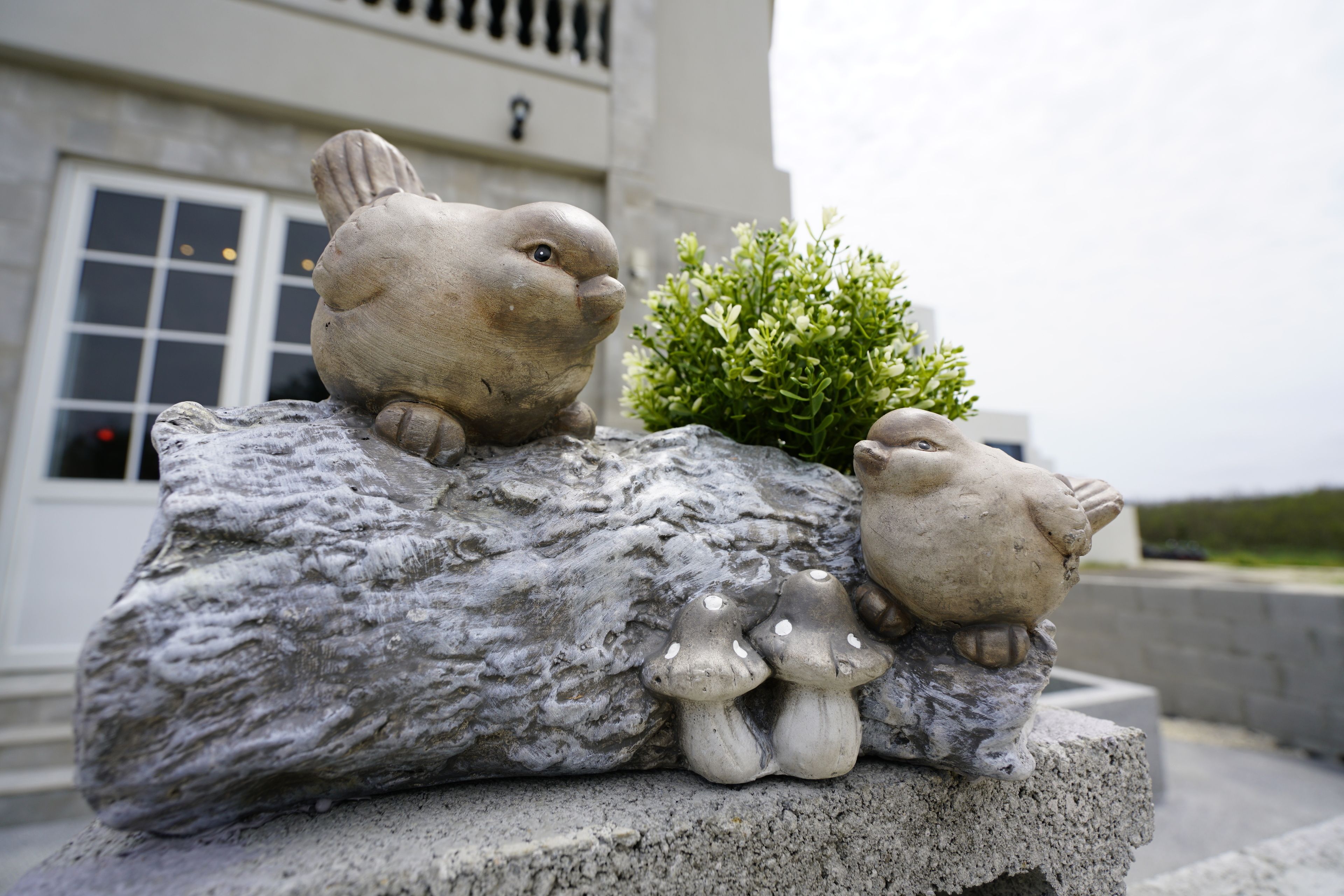 A rock with a rabbit and two mushrooms.