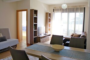 Familieleilighet, byutsikt | Oppholdsområde | TV