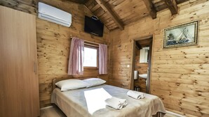 A wooden cabin room with a bed, a wardrobe, a window with checkered curtains, a sink, and a framed picture on the wall. - Lovely apartment in villa for 2 guests with A/C, WIFI, TV and terrace (Biograd Na Moru)