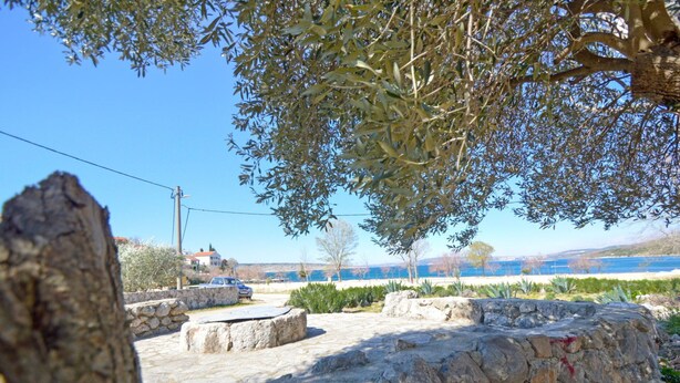A stone wall with a stone bench in a sunny outdoor setting. - Lovely apartment in villa for 2 guests with A/C, WIFI, TV and terrace (Biograd Na Moru)