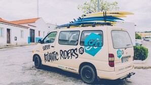 A van with surfboards on the roof, branded with "Atlantic Riders." - Atlantic Lodge (Aljezur)