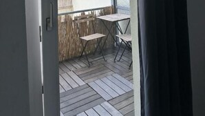 An open door to a balcony with a view of a building, a table, and two chairs. - dreams Düsseldorf (Düsseldorf)