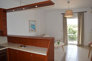 Una cocina moderna con armarios de madera, una encimera y un comedor con una mesa pequeña y sillas.