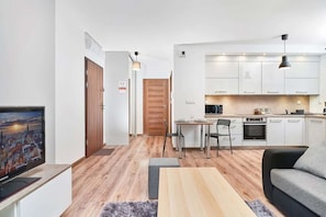 A modern apartment with a living room, kitchen, and dining area.