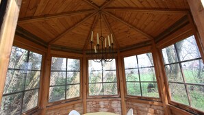 Une cabane en bois avec un plafond haut et de grandes fenêtres.