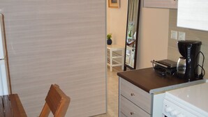 A compact kitchen with a dining area, a coffee maker, and a mirror. - Best House Petit Pylos Messinias (Pylos-Nestoras)
