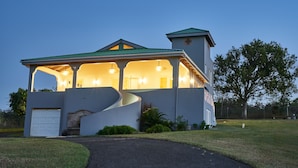 A modern house with a curved driveway, a covered porch, and a garage.