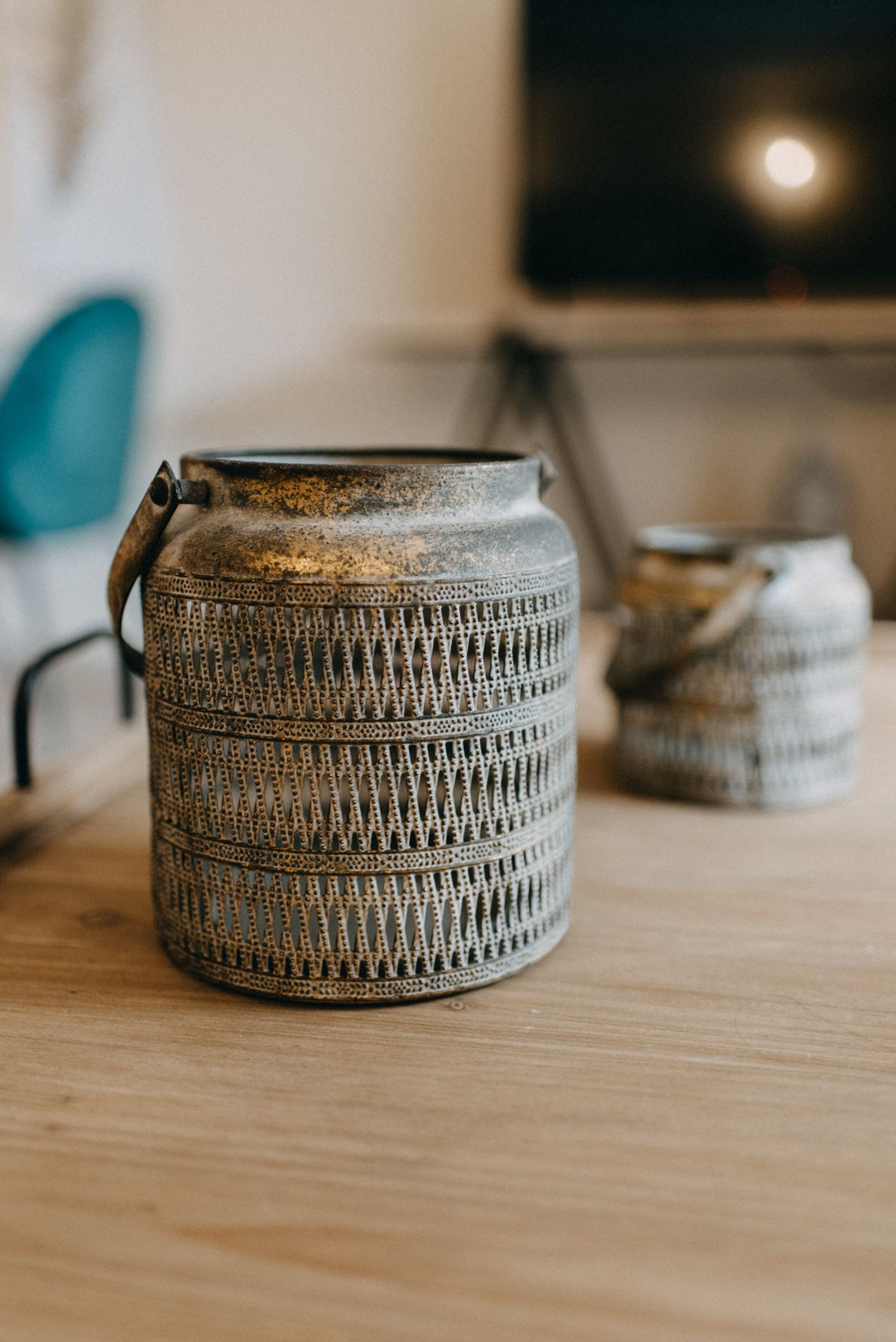 A metal container with a handle on a wooden surface.