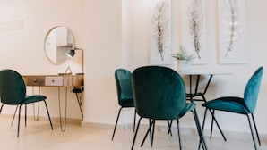 A modern room with a desk, two chairs, a round mirror, and three feather wall art pieces. - Best House Central Luxury Apartment (Patras)