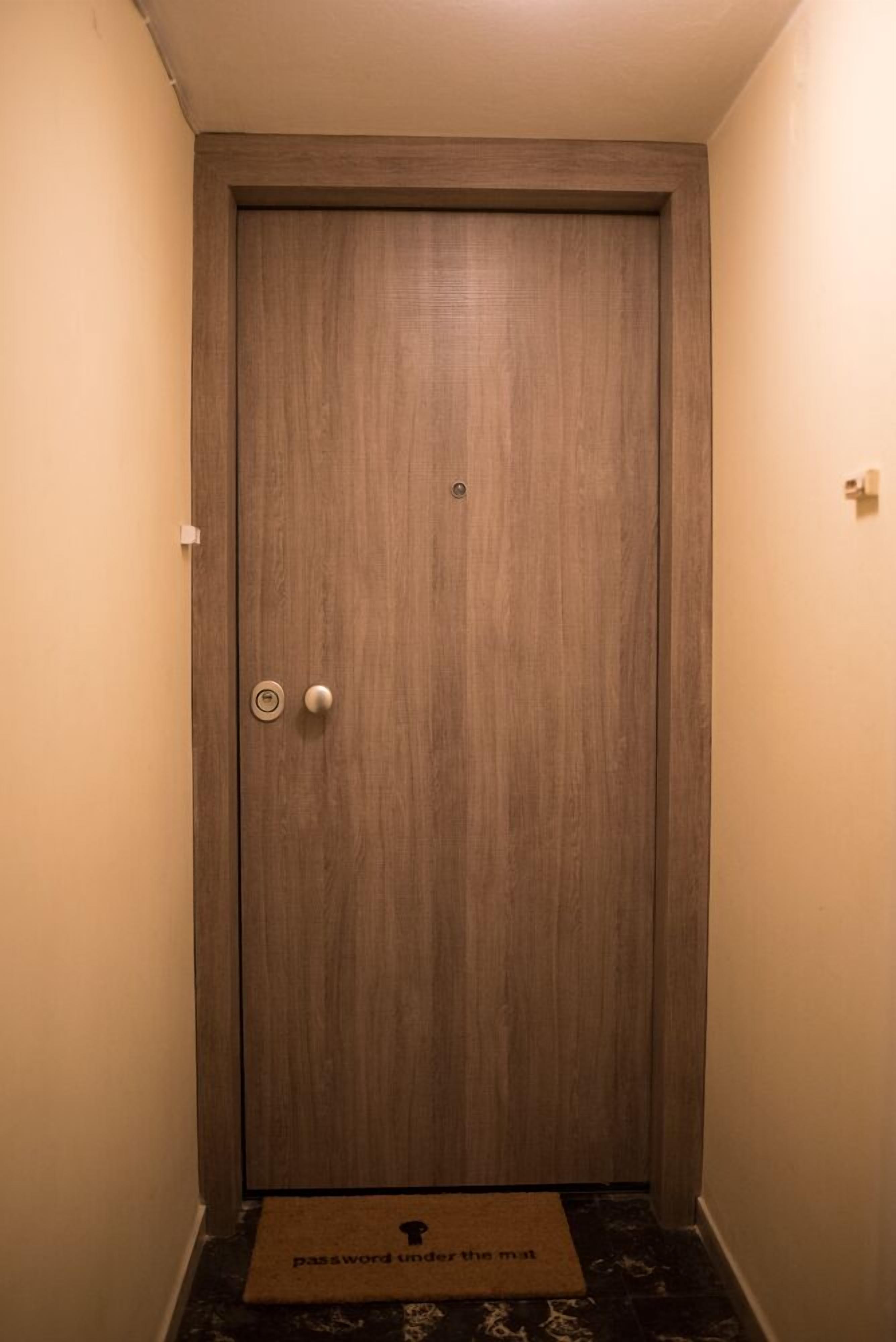 A closed wooden door with a round handle and a small lock.