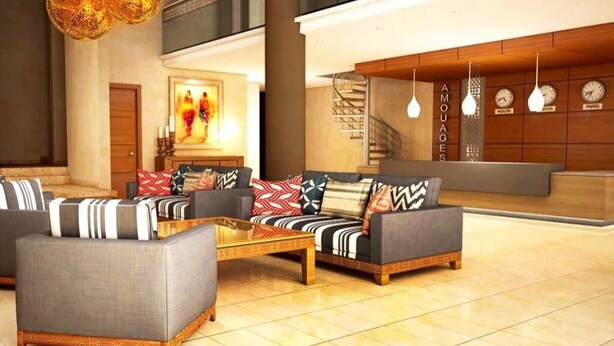 Eine großzügige Lobby mit einer Sofagruppe, einem Couchtisch und einer Treppe.