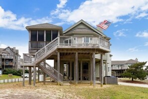 A two-story wooden building with a balcony and a flag.