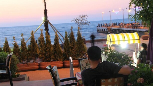 Restaurante frente al mar con terraza y vistas al océano, que combina decoración moderna y tradicional.
