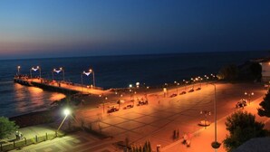 Un área de estacionamiento frente al mar, iluminada por farolas.