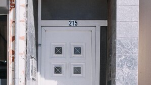 A white door with the number 215, set in a stone building with a marble column. - Best House Town View Apartment (Patras)