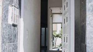A hallway with a marble floor leading to a door marked with the number 215. - Best House Town View Apartment (Patras)