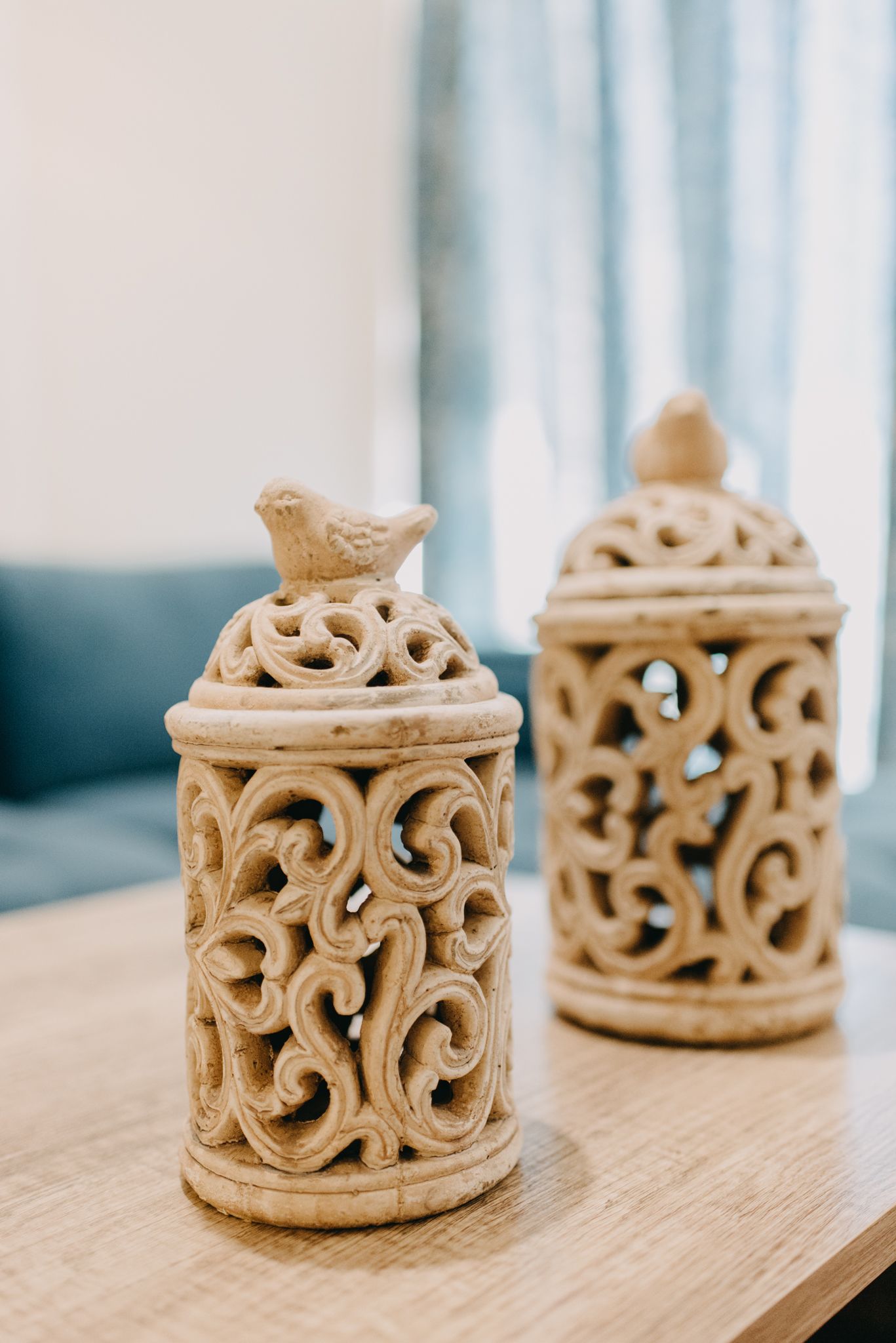 Two intricately carved ceramic containers on a wooden surface.