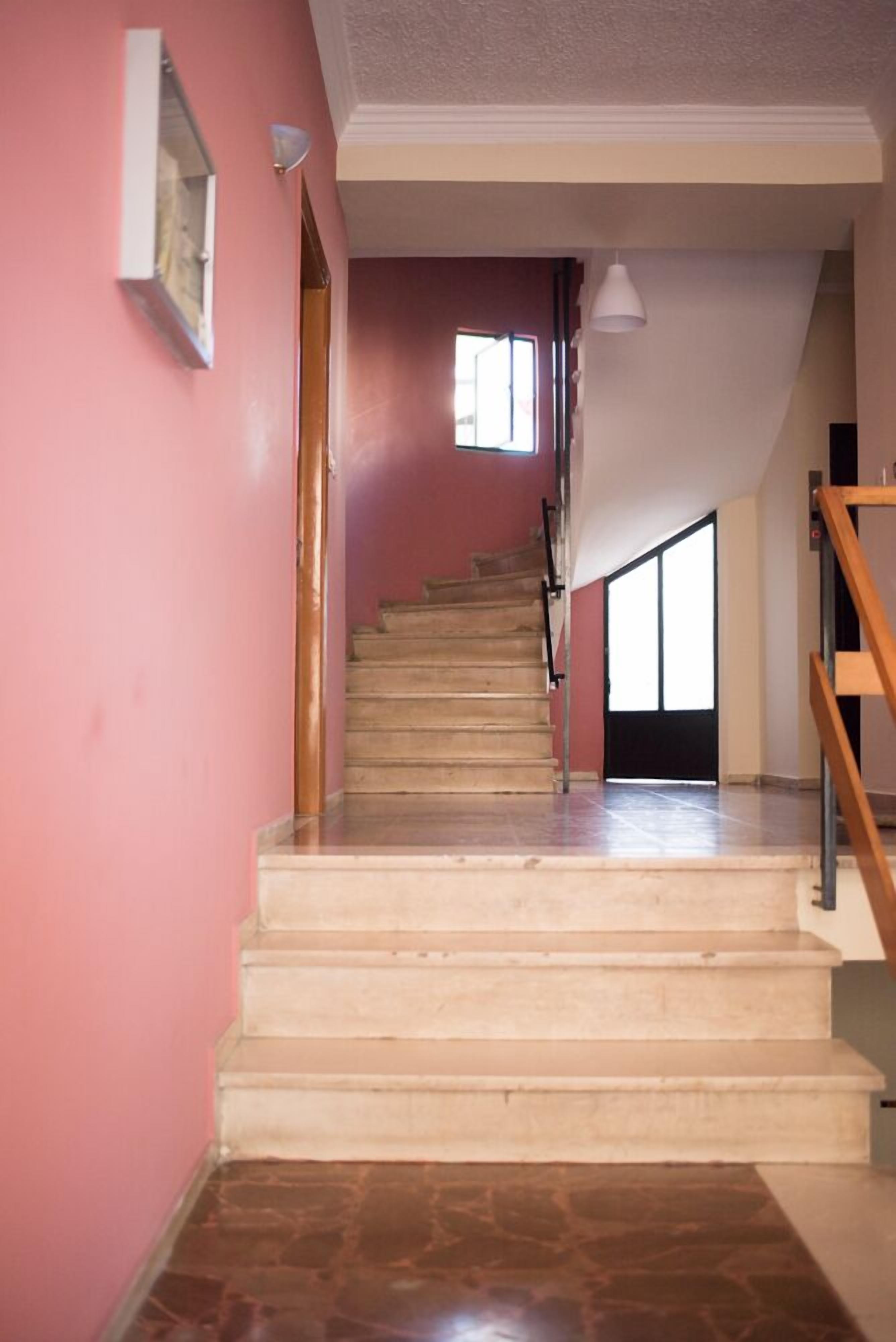 A staircase leading to a landing with a view of the outside.