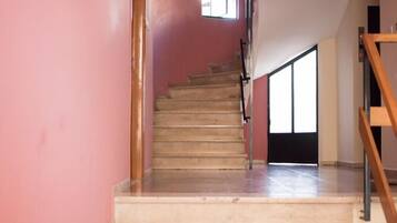 A staircase leading to a landing with a view of the outside.