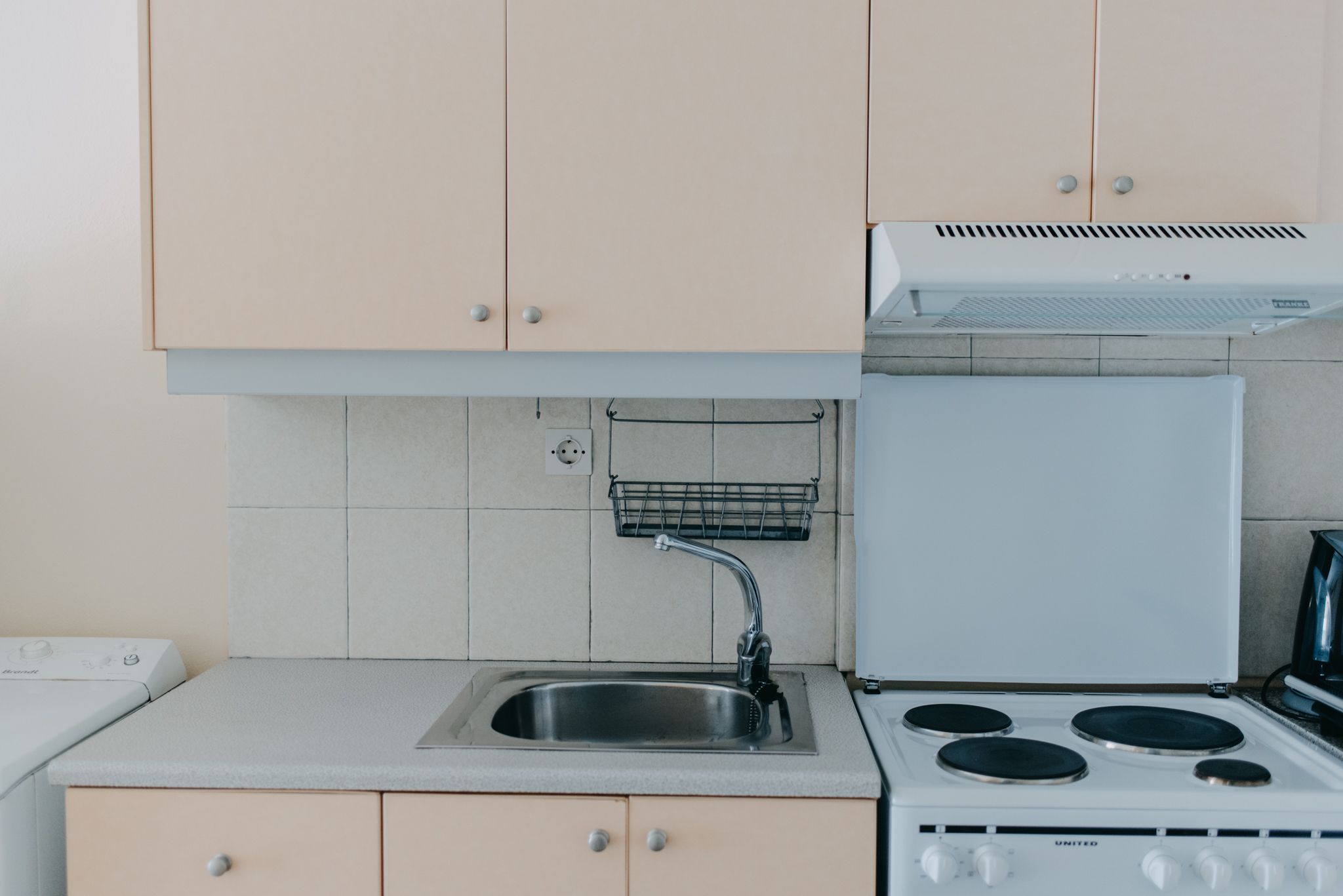 A kitchen with a sink, stove, and cabinets.