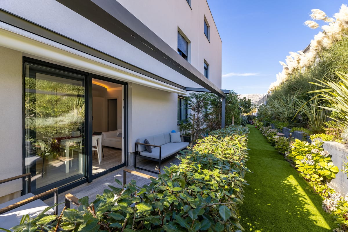 A modern house with a glass door leading to a patio area.