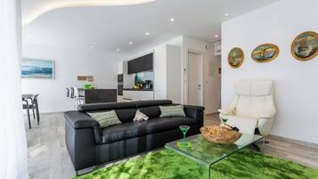 Apartamento Deluxe, 2 habitaciones, vistas al mar | Zona de estar | Televisión de pantalla plana de 55 pulgadas con canales premium