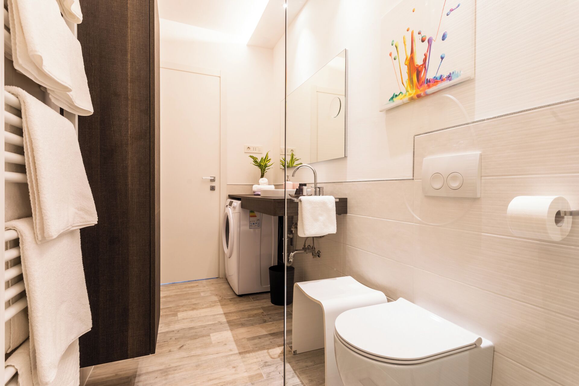 A modern bathroom with a toilet, sink, and washing machine.