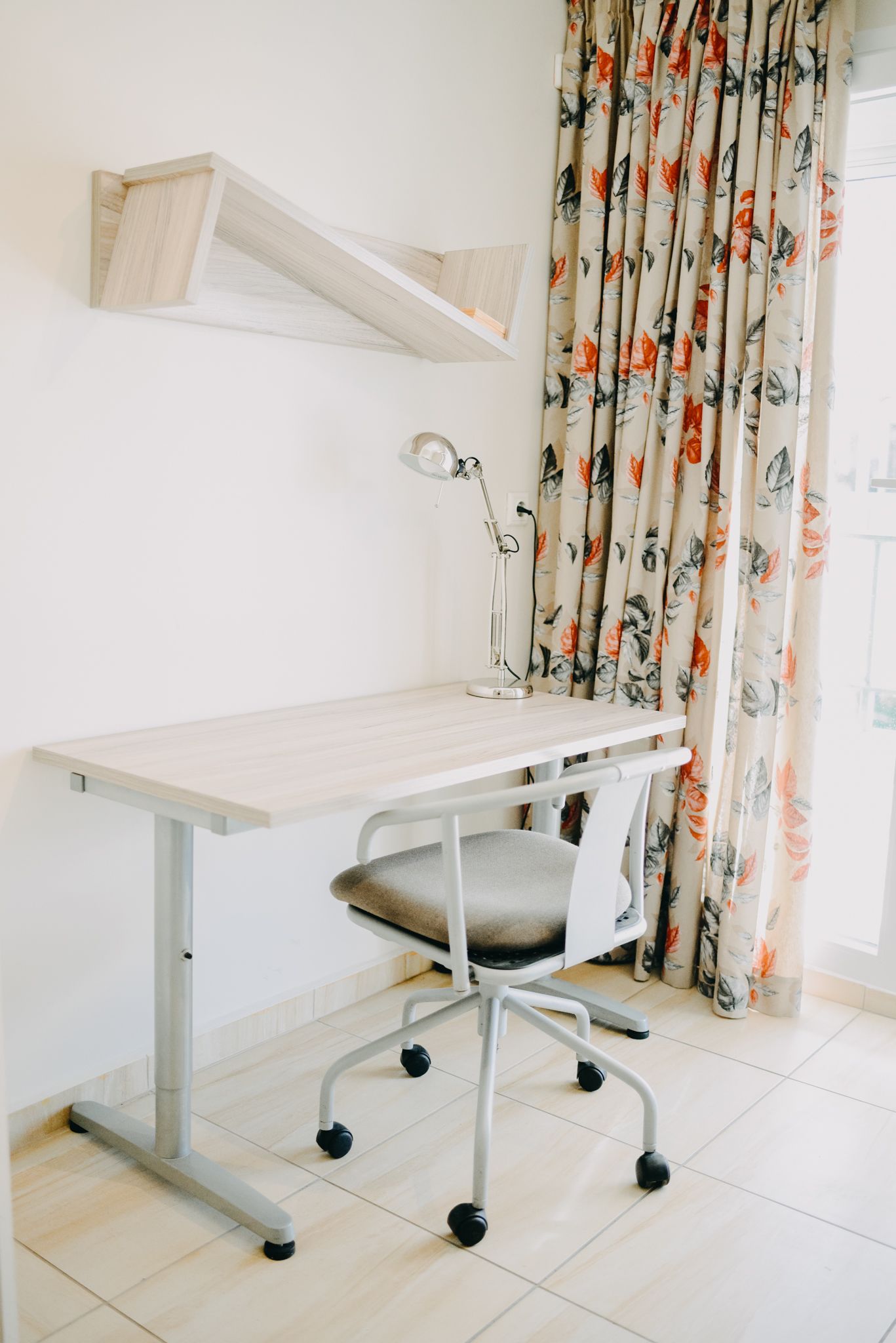 A study area with a desk, chair, and lamp.