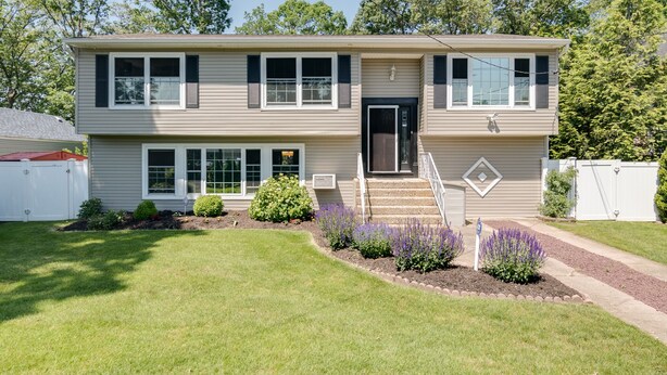 A two-story house with a front porch, a garage, and a well-maintained lawn.