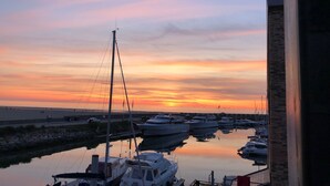 Un port de plaisance où des bateaux sont amarrés au moment du coucher du soleil.