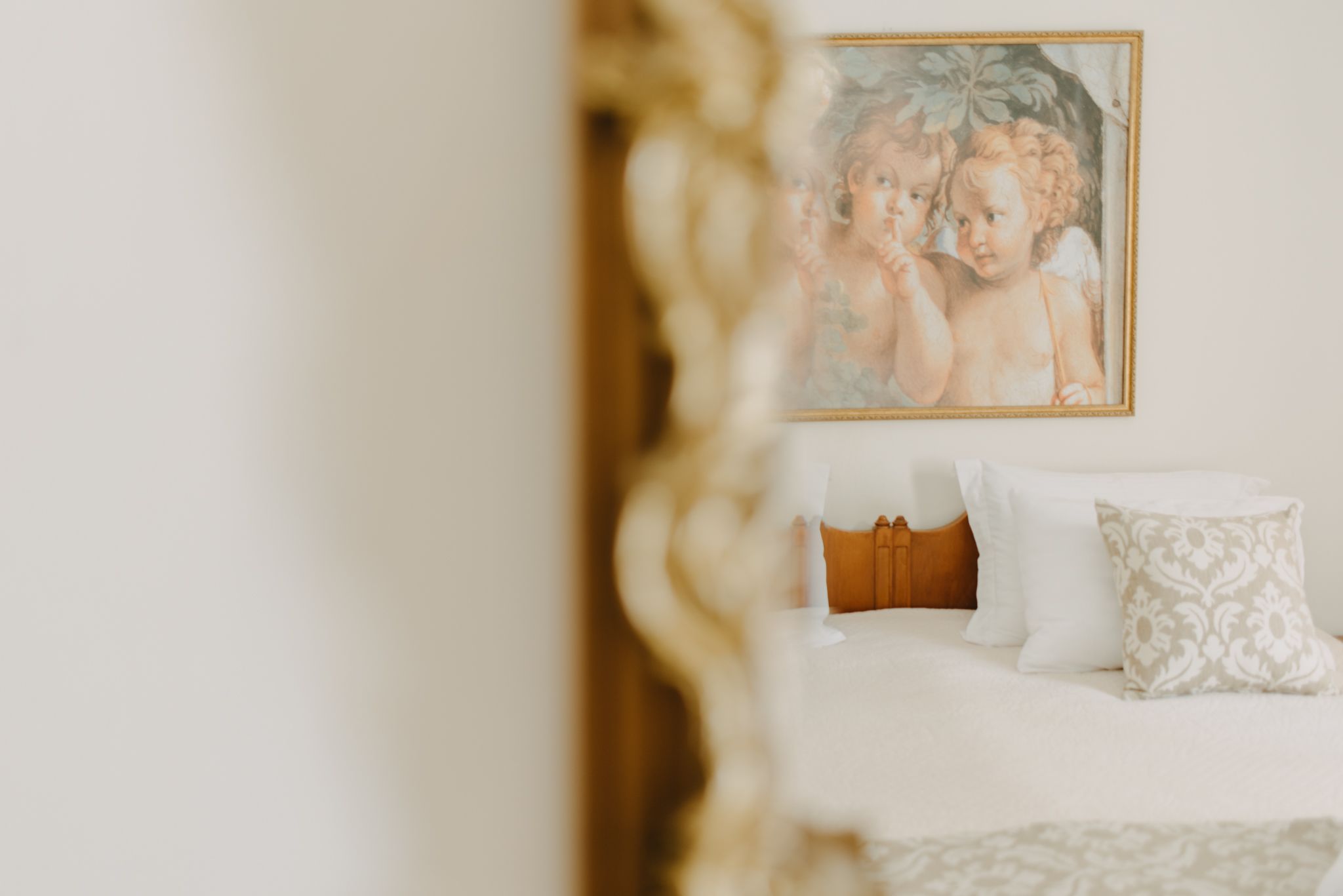 Un dormitorio con una cama, almohadas y un cuadro en la pared.
