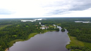 Une rivière serpente à travers une zone densément boisée, avec plusieurs bâtiments situés le long de ses rives.