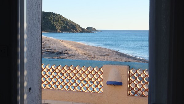 Une vue d’une plage avec une clôture en bois au premier plan.