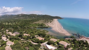A coastal area with a beach, houses, and a mountainous backdrop. - Residence Fium del Cavo (Zonza)