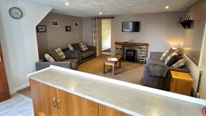 Una sala de estar con sofá, mesa de centro y chimenea.