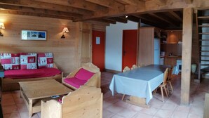 Un intérieur en bois comprenant un canapé, une table et un coin cuisine.