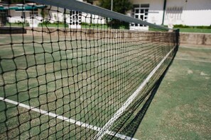 A tennis court with a net in the foreground.