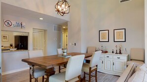 A dining area with a wooden table and chairs, a white cabinet, and a 'NO SURFING' sign on the wall.