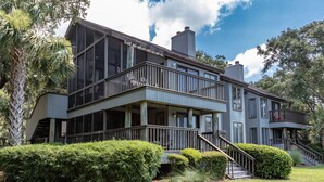 A two-story building with a balcony and a staircase leading to the upper level.