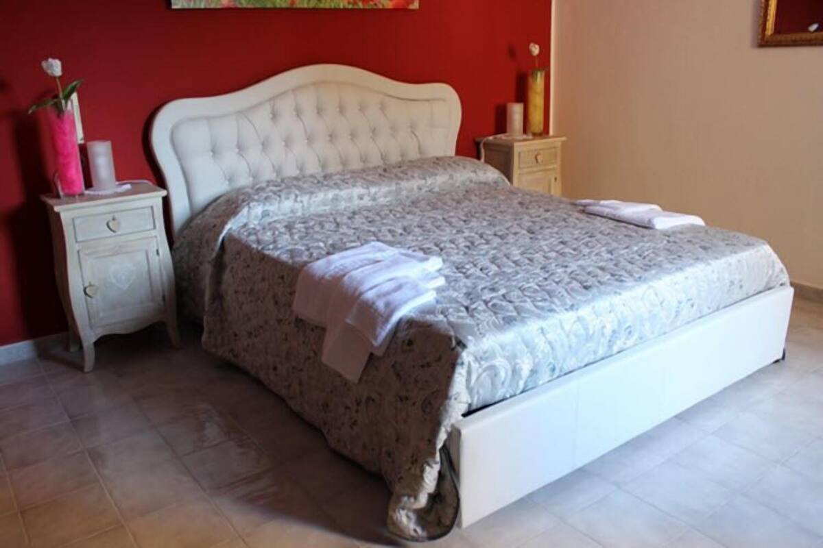 A neatly made bed with a floral bedspread and a white headboard.
