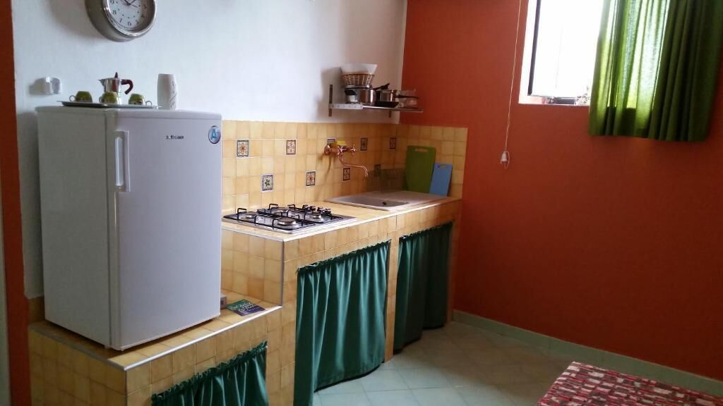 A compact kitchen with a refrigerator, stove, and sink.