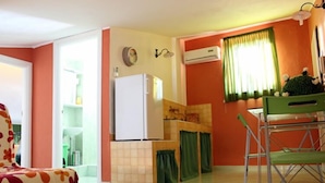 A compact kitchen with a refrigerator, a sink, and a dining area with a chair. - B&B Santantonio (Crecchio)
